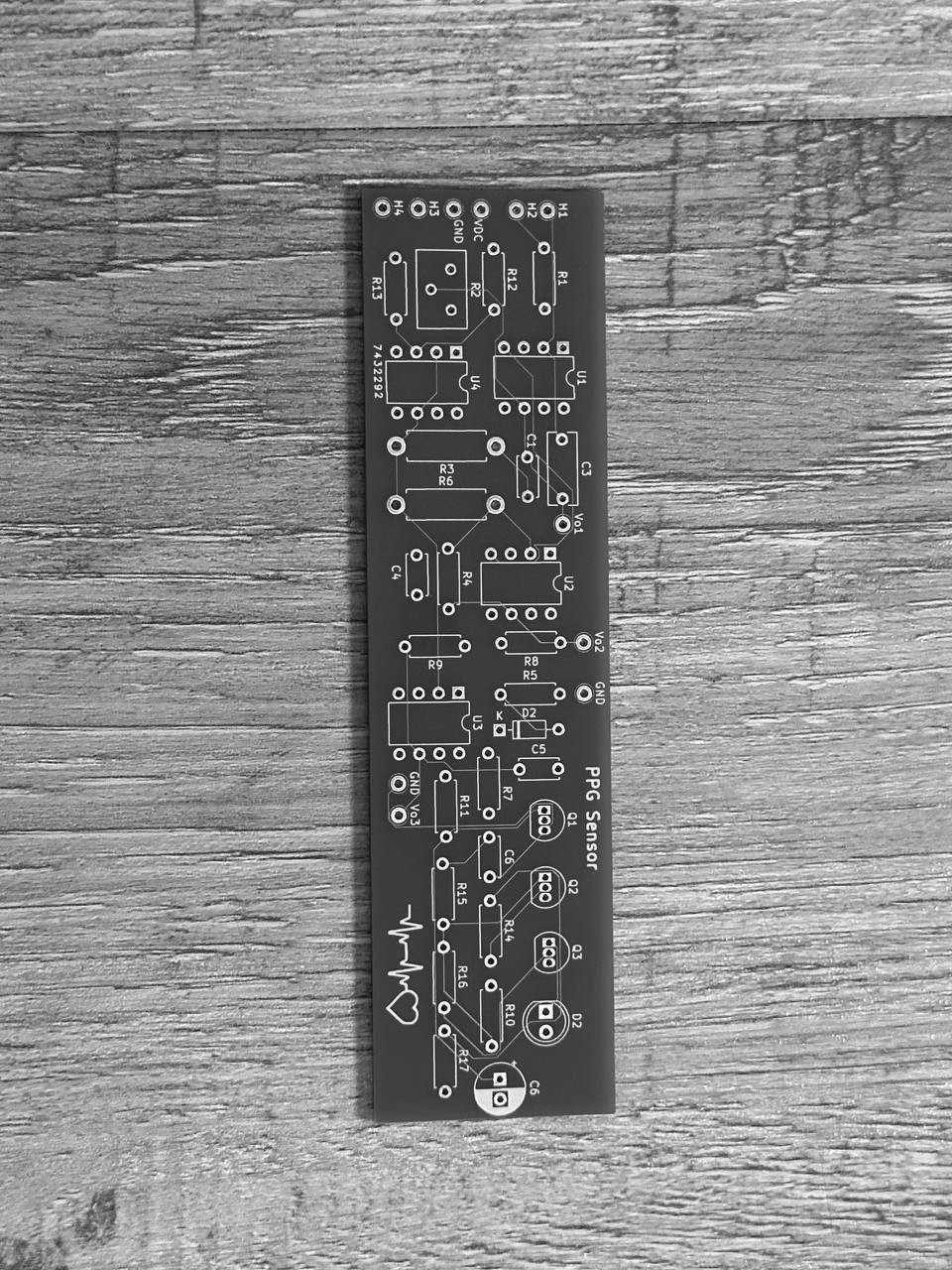 The bare PPG Sensor board from JLCPCB: green solder mask, white silkscreen, footprints for U1 to U4, Q1 to Q3, and a heartbeat glyph.